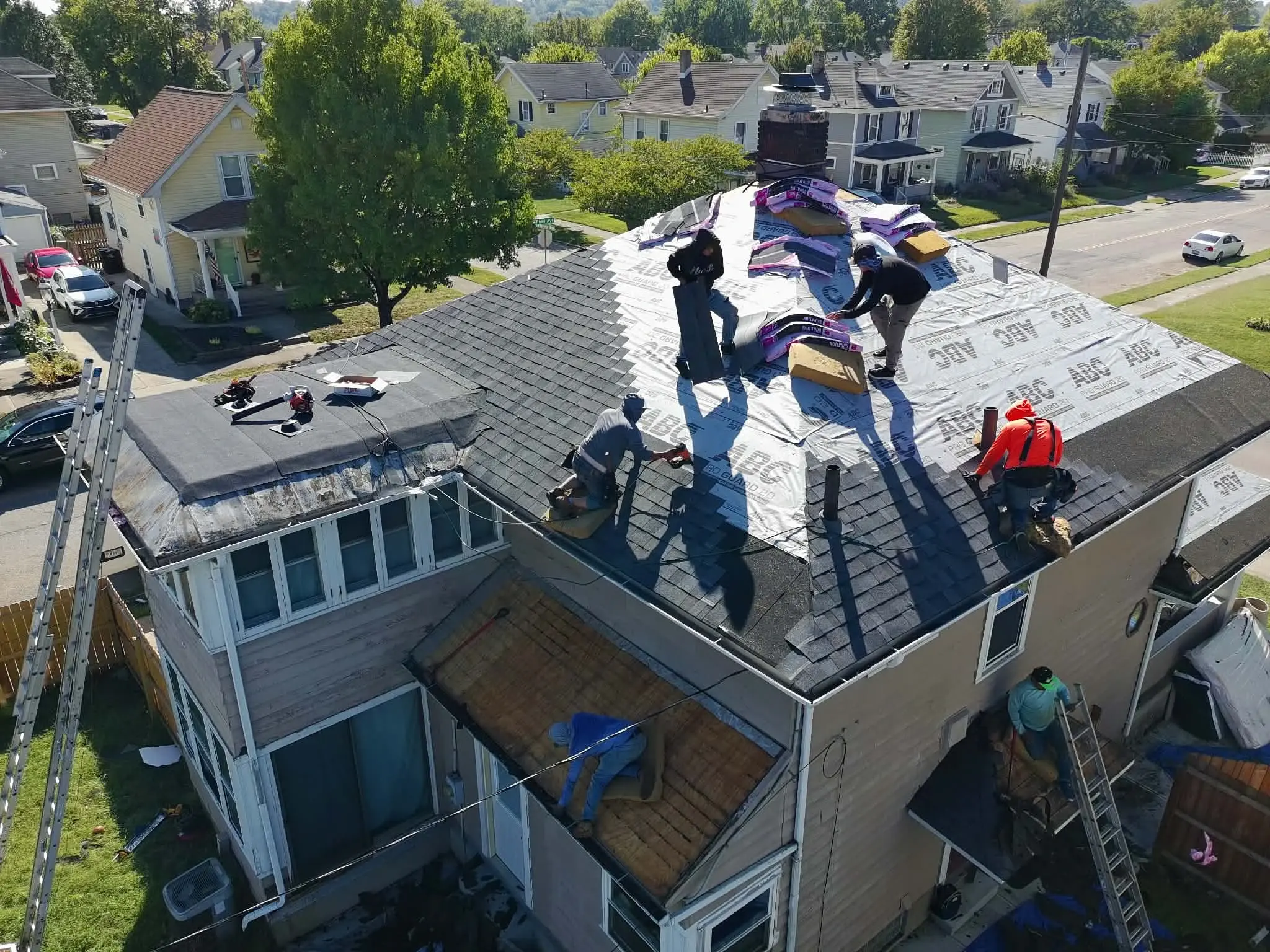 Residential asphalt shingle roof installation in progress on a suburban home