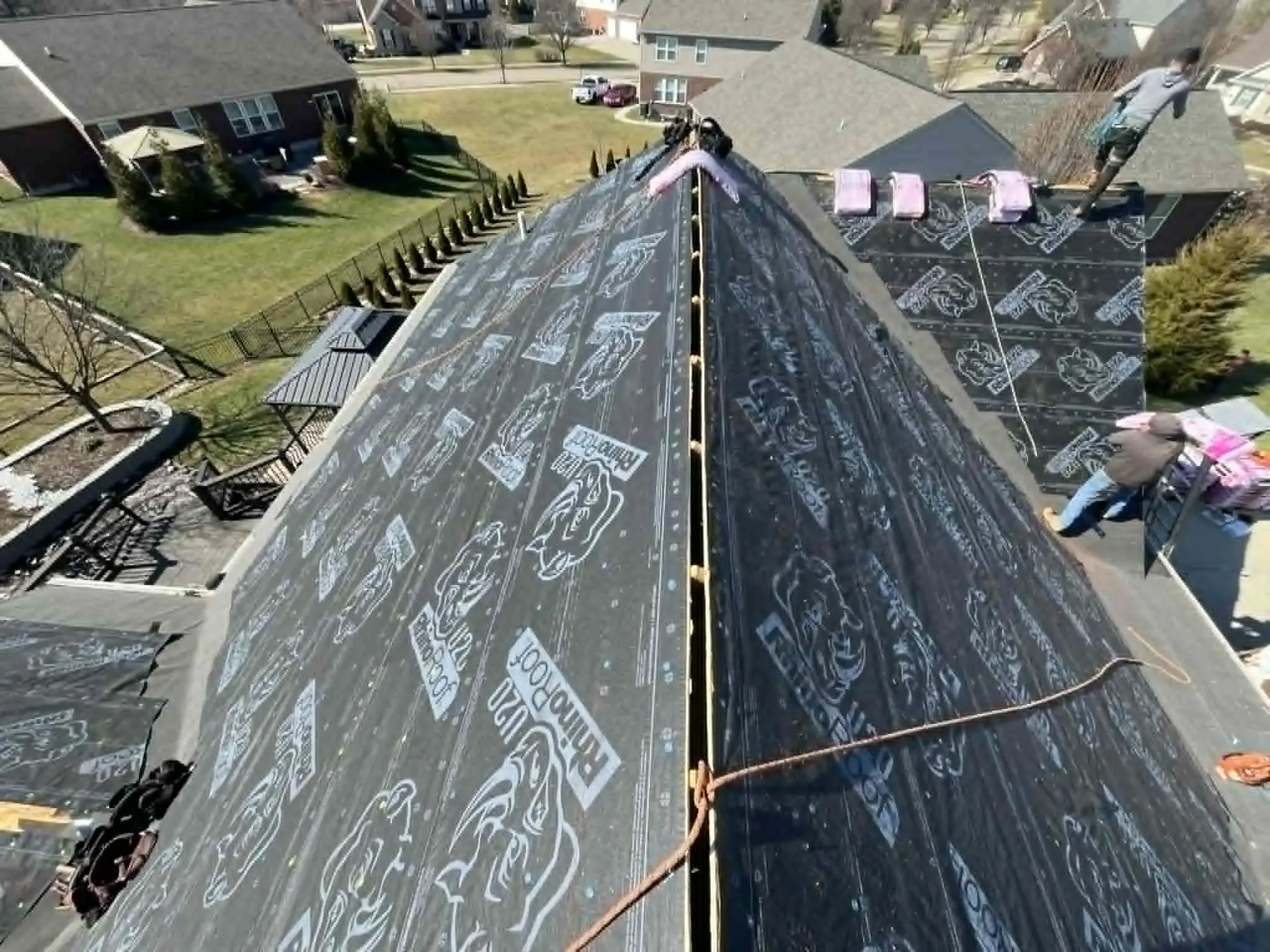 Roofer repairing storm-damaged shingles on a residential roof
