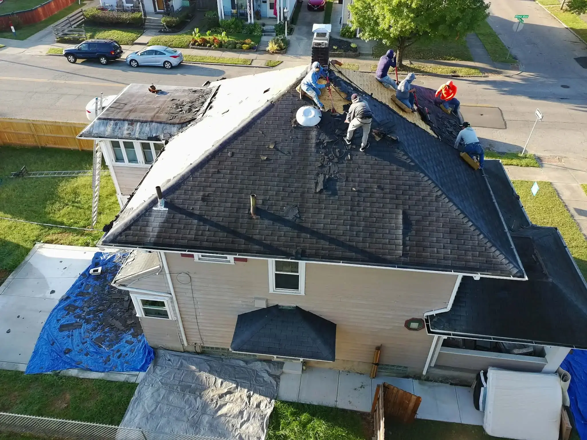 Dominion Roofing crew installing shingles and gutters on an Ohio residential home