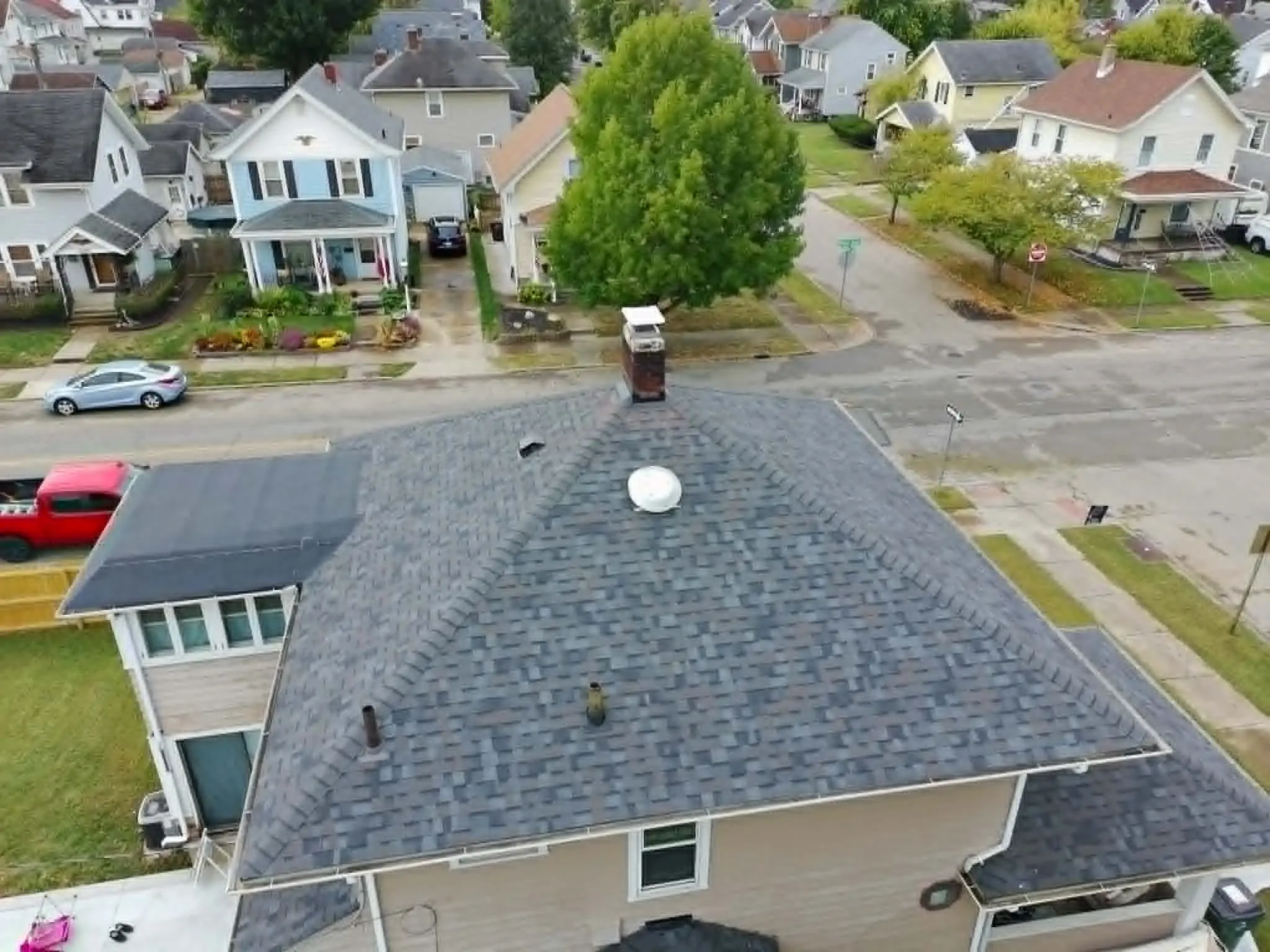 Aerial drone view of a completed Dominion Roofing project on a suburban home