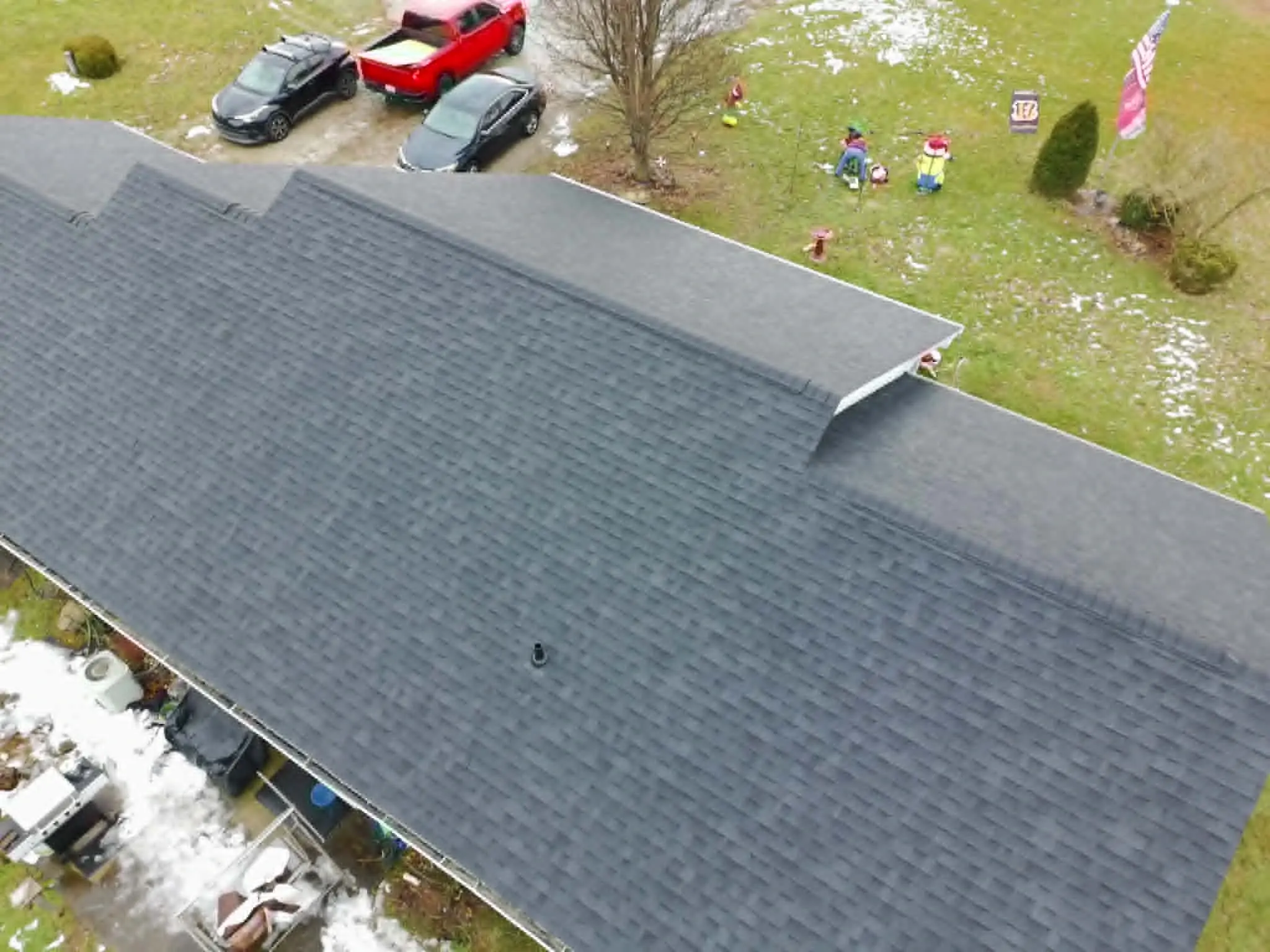 Wide view of a finished asphalt shingle roof replacement on a residential home