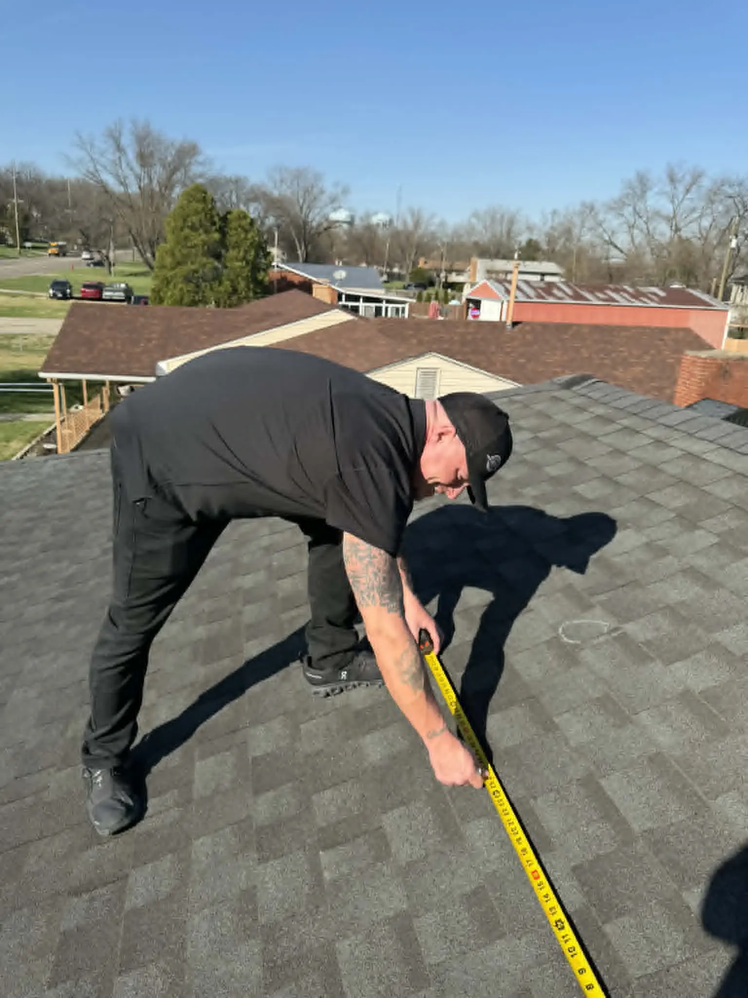 Dominion Roofing contractor taking precise on-site measurements for a project