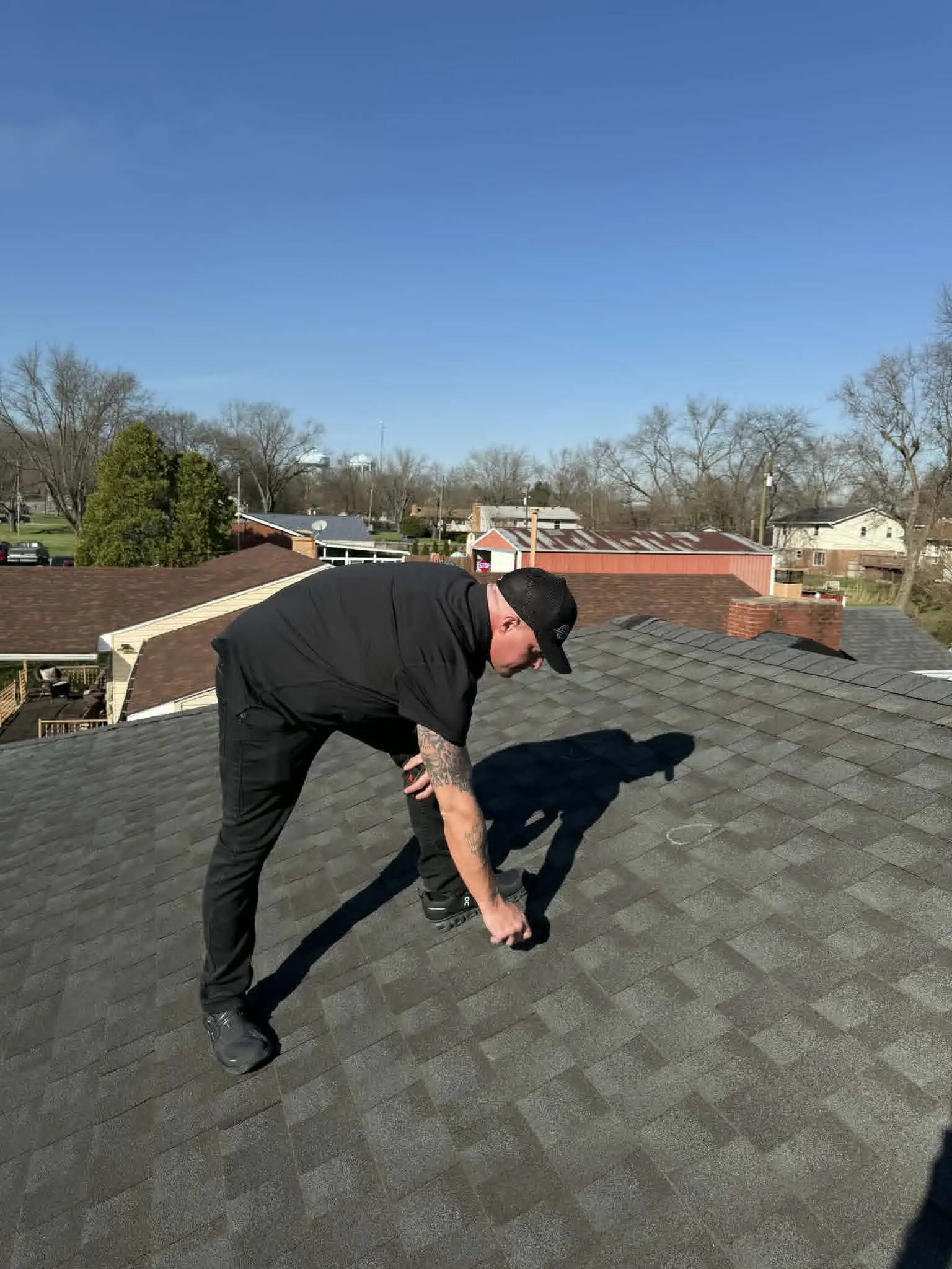 Dominion Roofing specialist inspecting a residential roof for damage