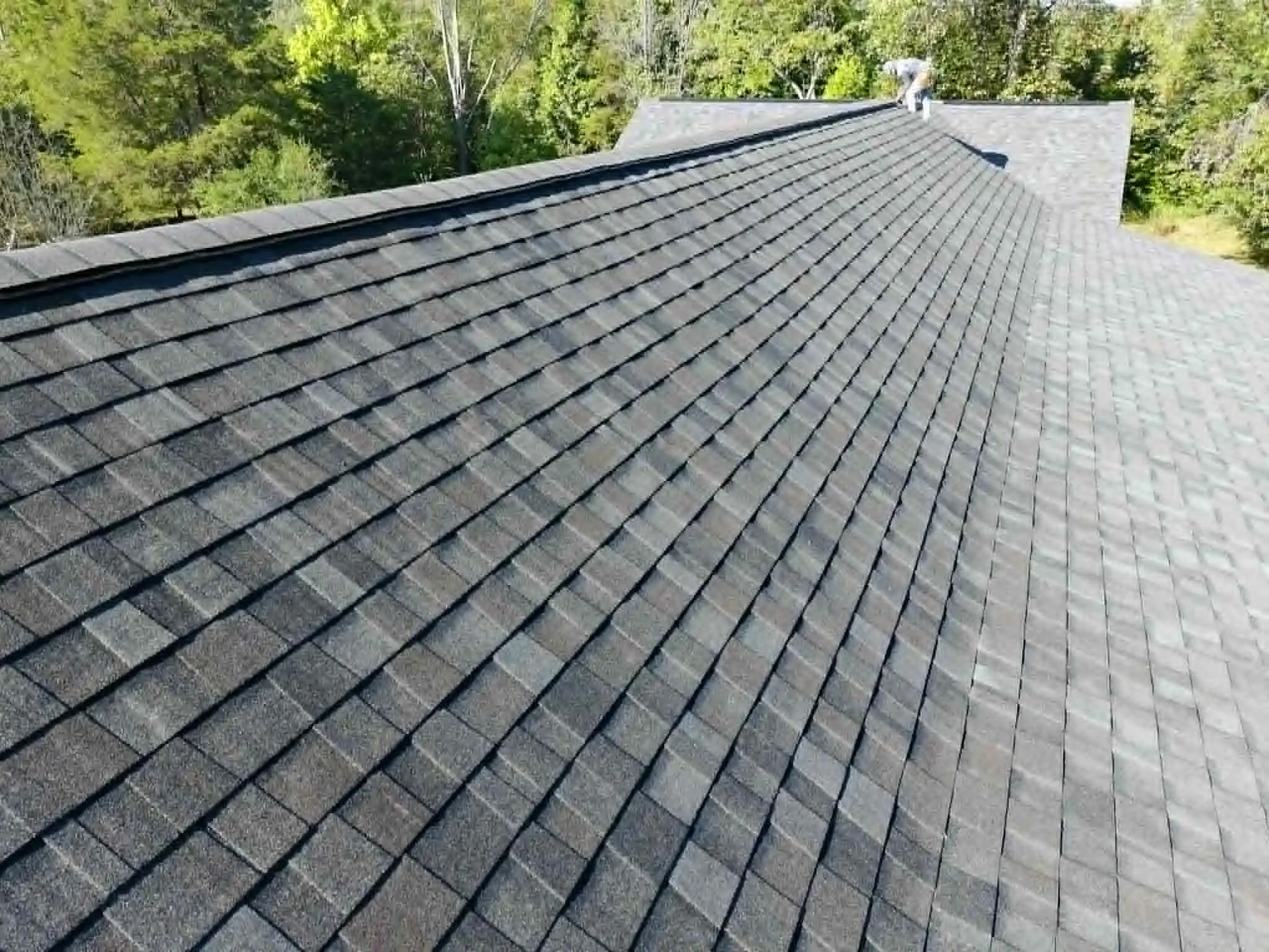 Detail of shingle alignment, nail placement, and ridge cap on a finished roof