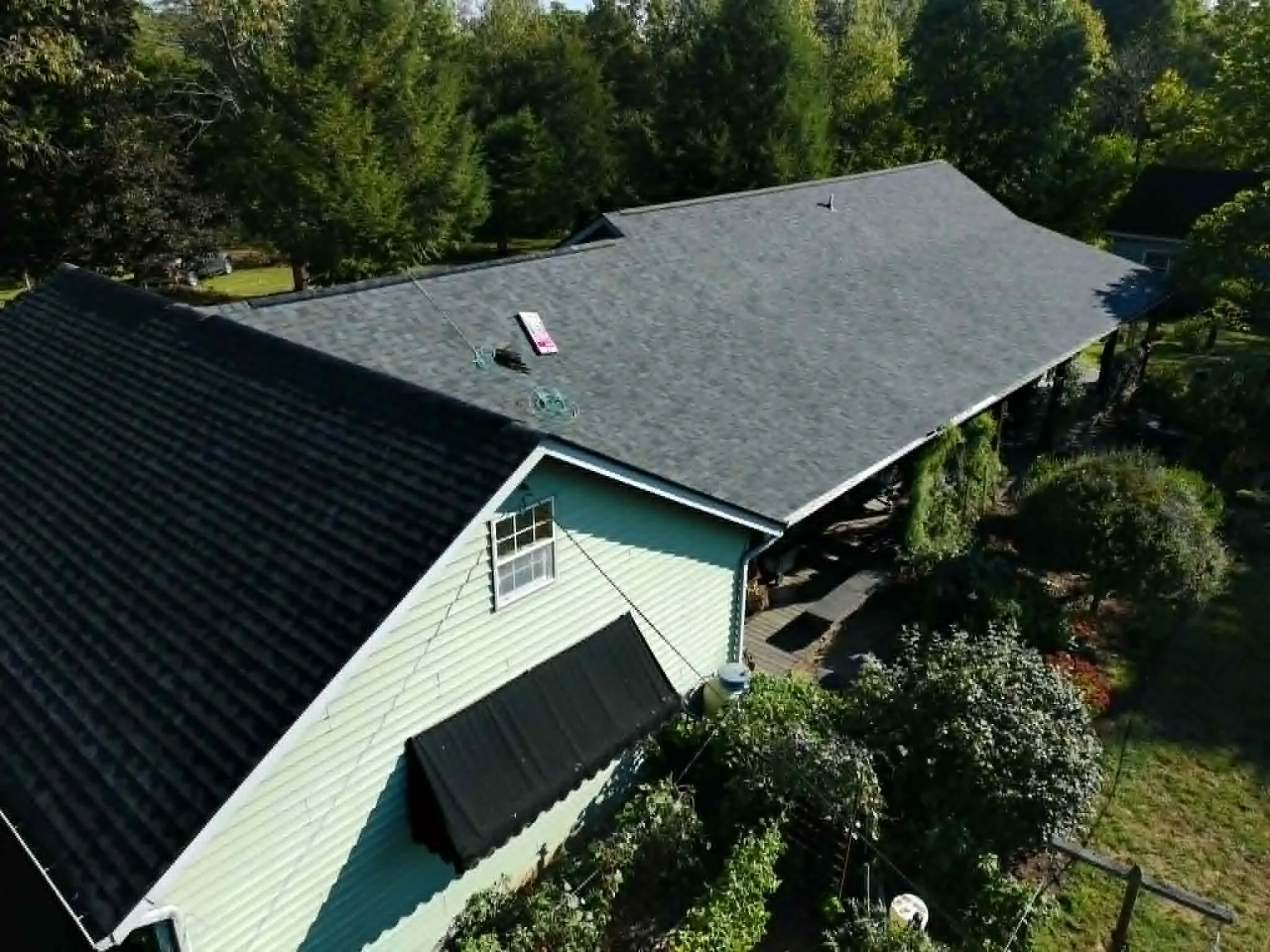 Elevated overview of a multi-plane residential roof during shingle installation