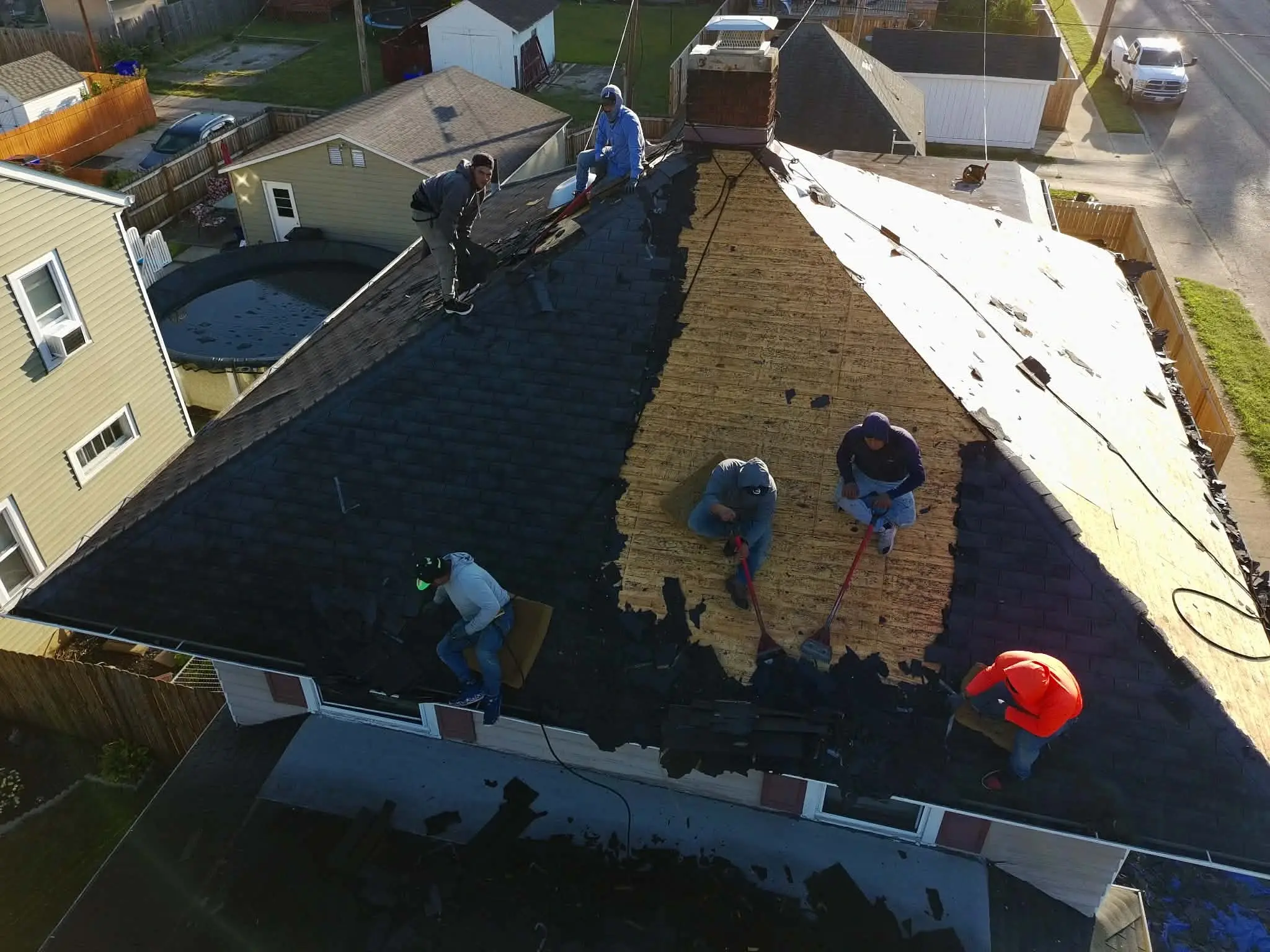 Old shingles being removed during a full roof tear-off and replacement