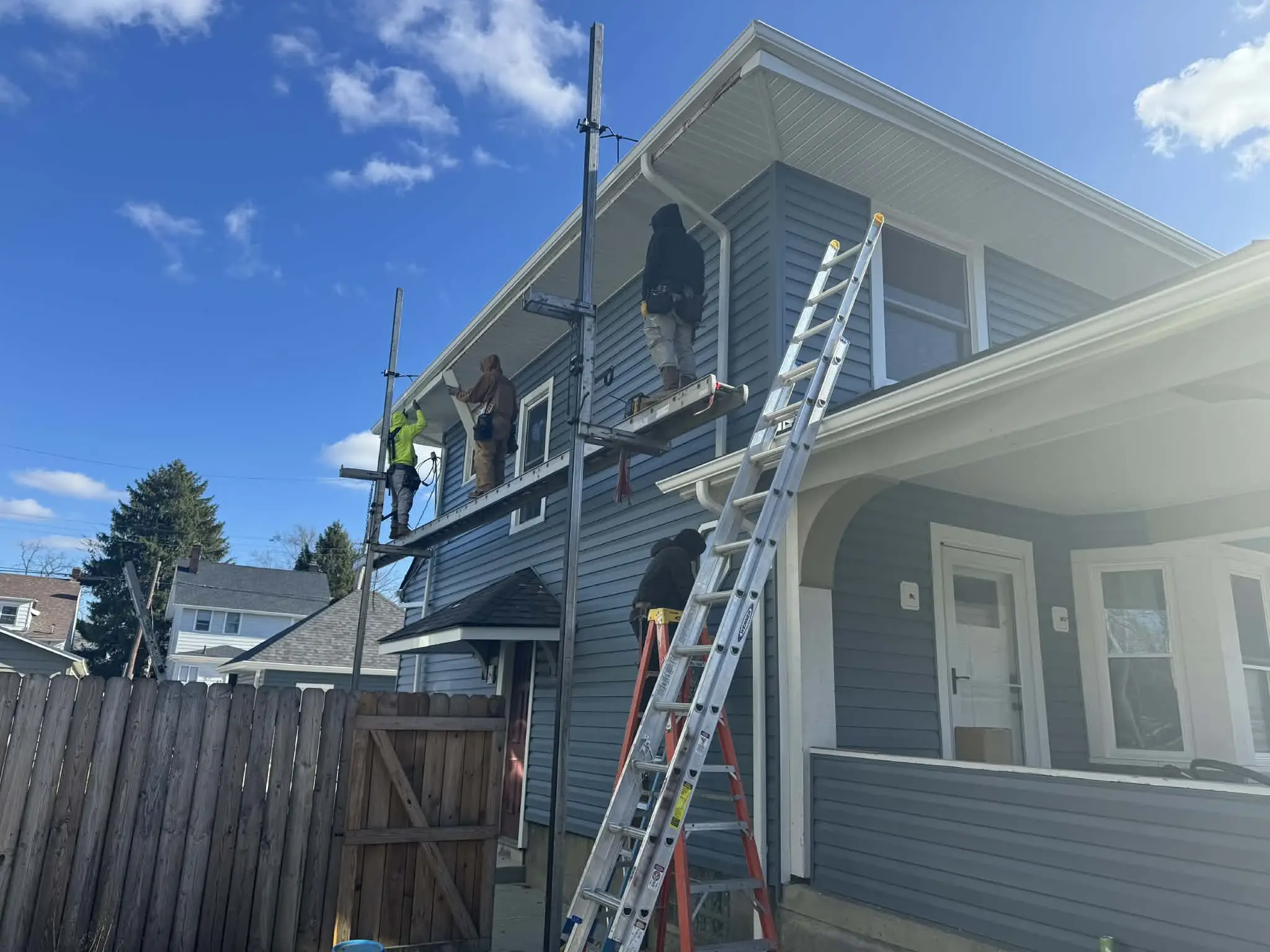 Crew installing new siding panels on a residential home exterior