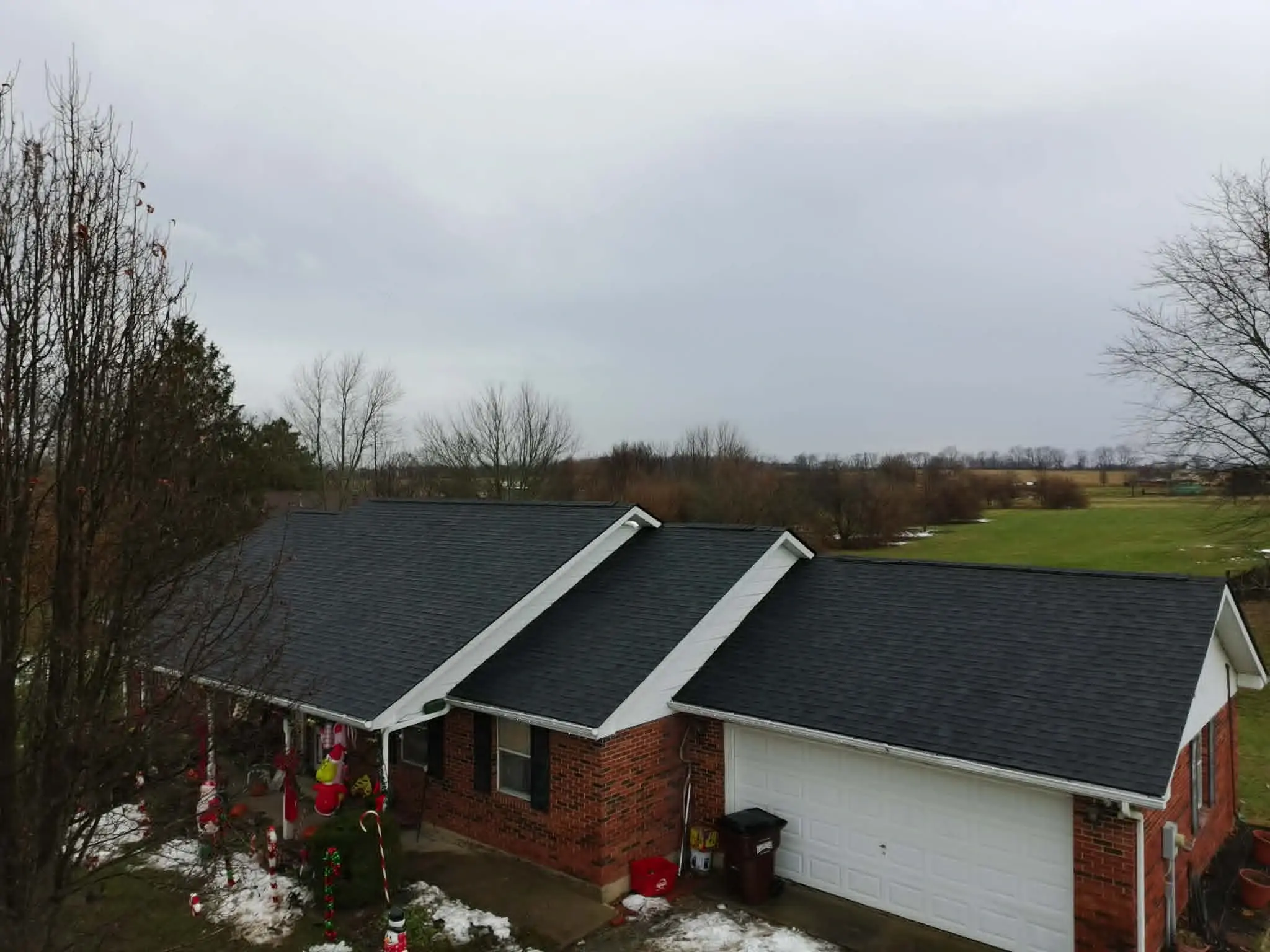 Front elevation of a home with a new white asphalt shingle roof and updated gutters