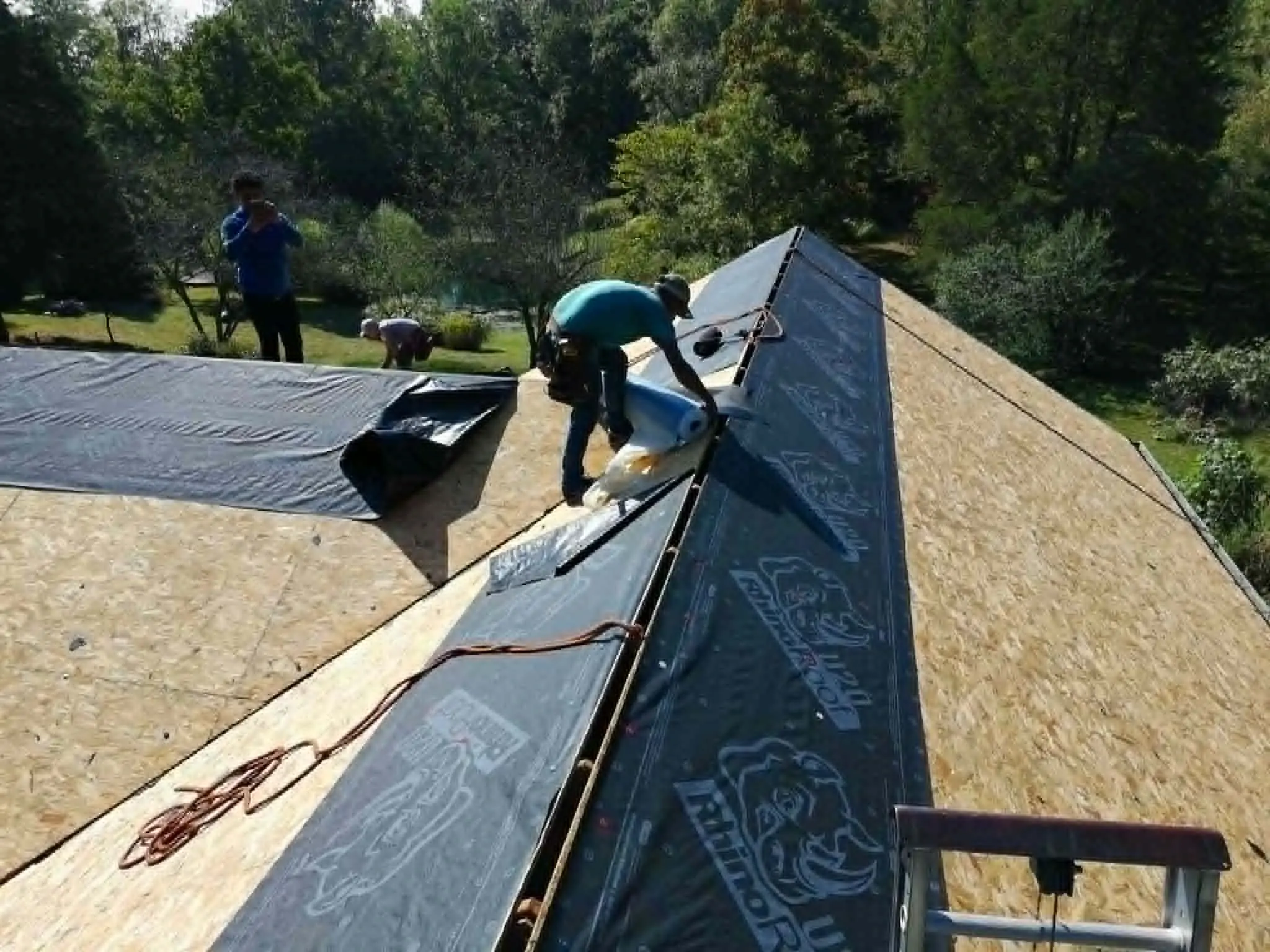 Crew converting a wood shake roof to new architectural asphalt shingles
